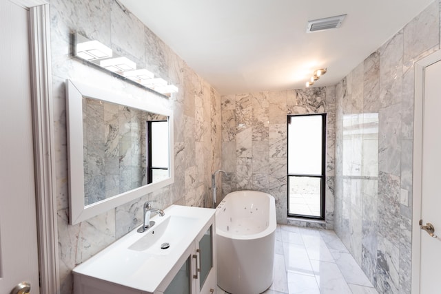 bathroom with a bath, tile walls, and vanity