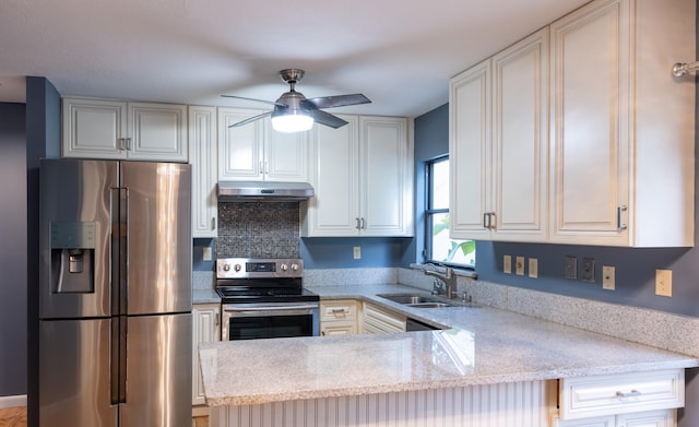 kitchen with appliances with stainless steel finishes, light stone counters, sink, kitchen peninsula, and ceiling fan