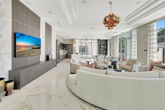 living room featuring a chandelier, a raised ceiling, and french doors