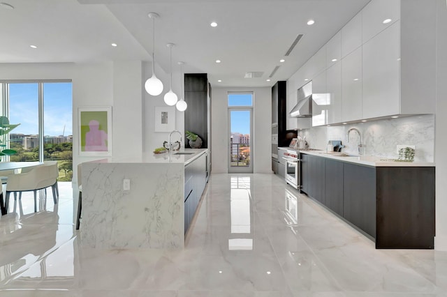 kitchen with a wealth of natural light, decorative light fixtures, tasteful backsplash, and white cabinetry