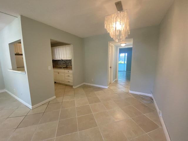 tiled empty room with an inviting chandelier and sink