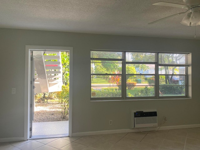 tiled spare room with a wall mounted AC, a textured ceiling, and ceiling fan