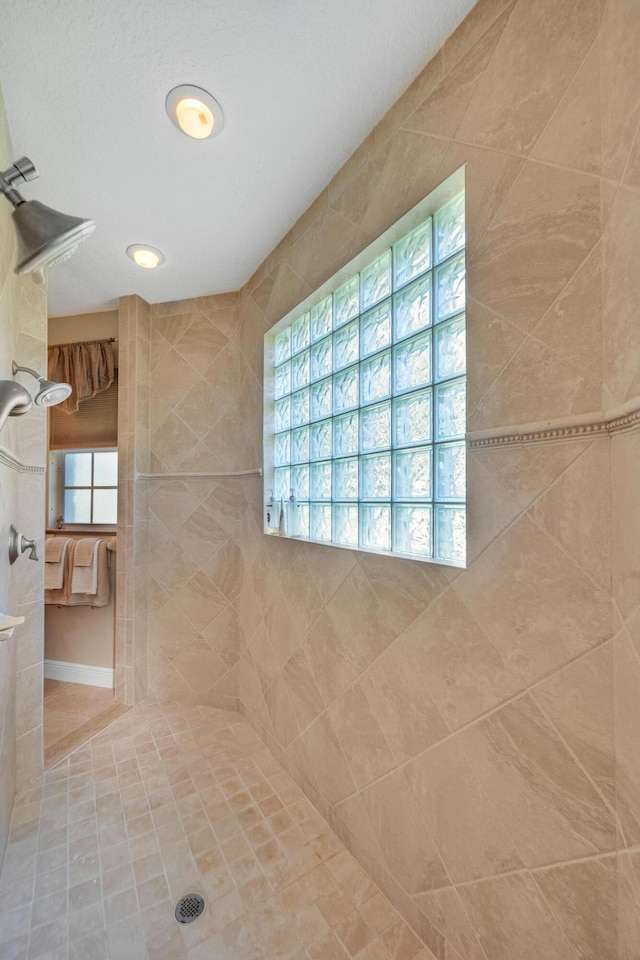 bathroom featuring a wealth of natural light and a tile shower