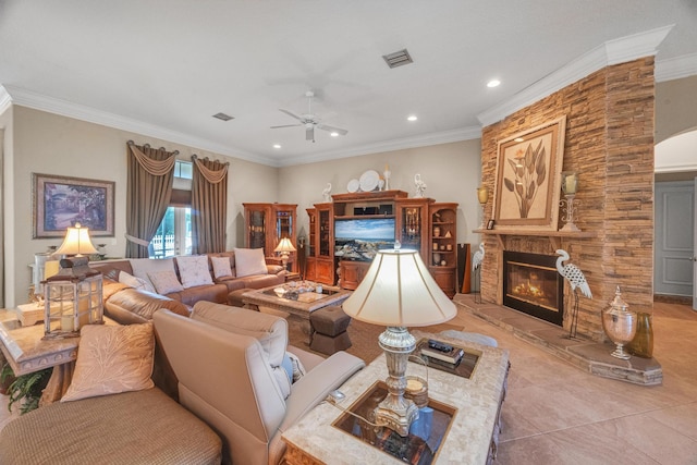 tiled living room featuring crown molding, a fireplace, and ceiling fan