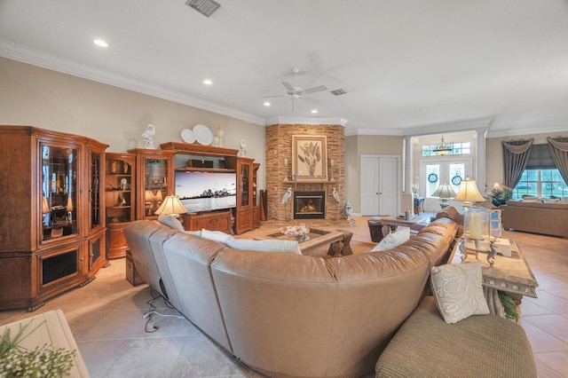 living room with ornamental molding, ceiling fan, a fireplace, and light tile patterned floors