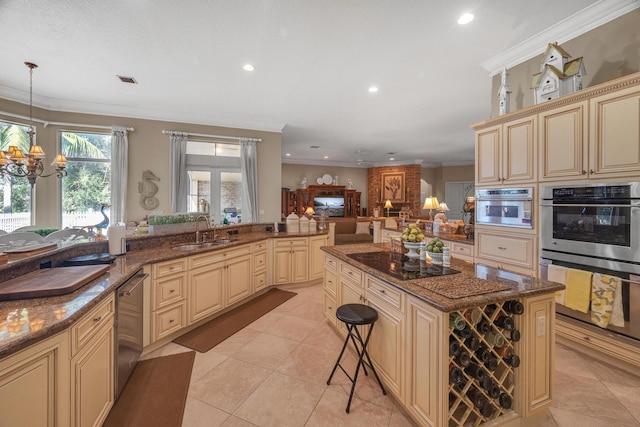 kitchen with sink, a kitchen bar, hanging light fixtures, stainless steel appliances, and a notable chandelier