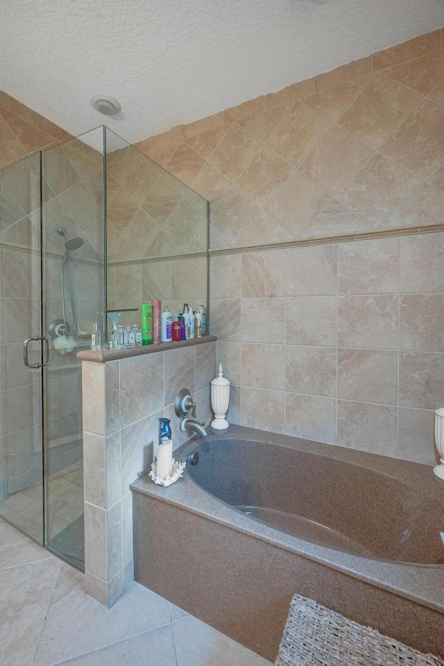 bathroom with independent shower and bath, a textured ceiling, and tile patterned flooring