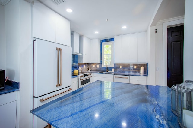 1970 S Dixie Hwy Unit R5, West Palm Beach, FL 33401 - kitchen featuring high quality appliances, wall chimney exhaust hood, white cabinetry, decorative backsplash, and modern cabinets