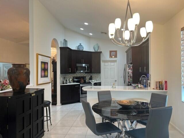 dining area featuring light tile patterned floors, a chandelier, and sink