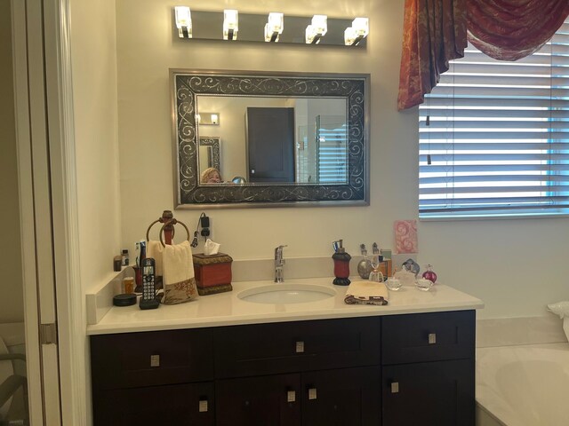 bathroom featuring a tub to relax in and vanity