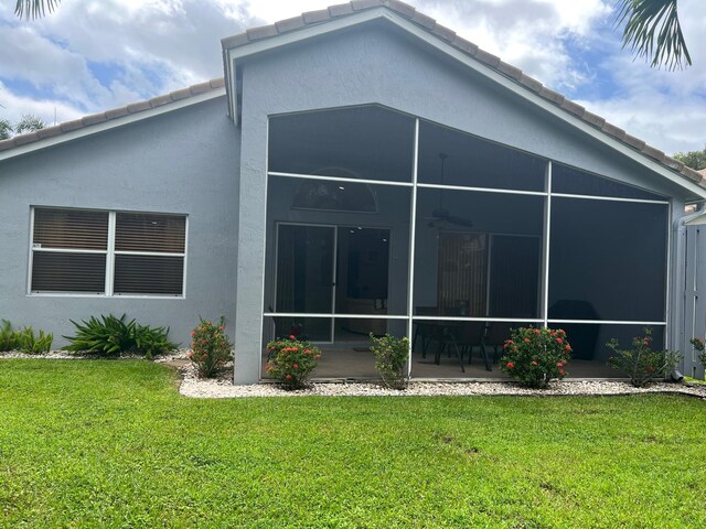 back of house with a sunroom and a yard