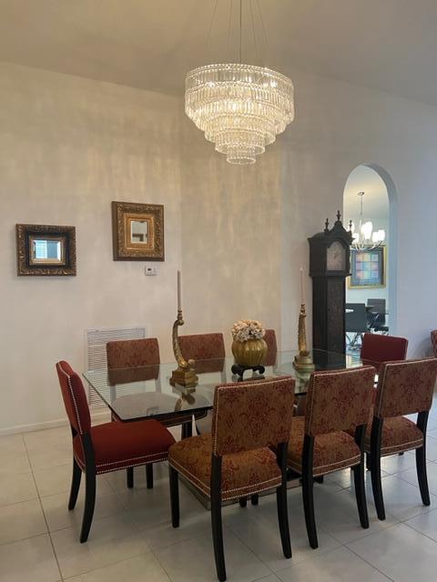 tiled dining room with a chandelier