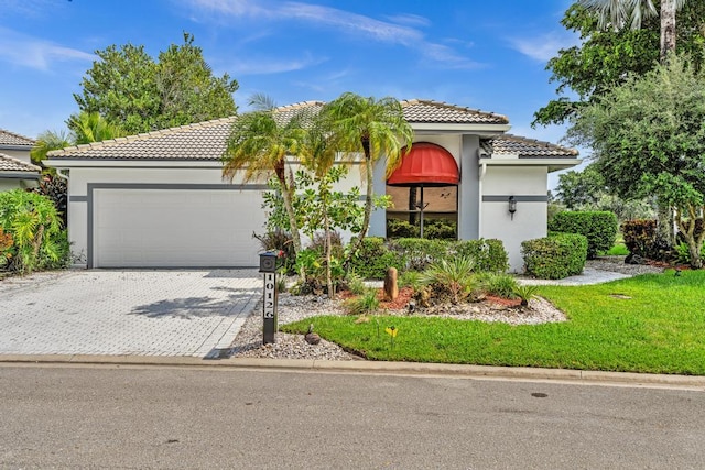 mediterranean / spanish-style house with a garage and a front lawn