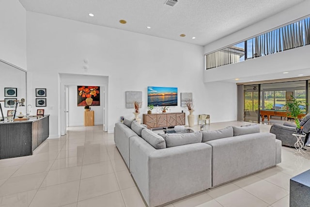 tiled living room featuring a textured ceiling and a high ceiling