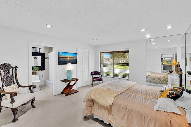 bedroom with a textured ceiling and connected bathroom