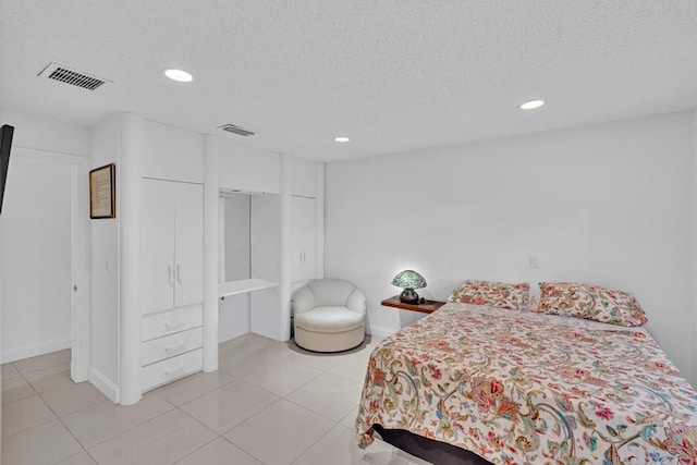 tiled bedroom featuring a textured ceiling