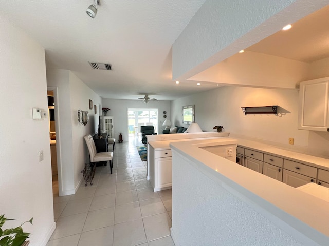 kitchen with ceiling fan, a textured ceiling, light tile patterned floors, and white cabinetry