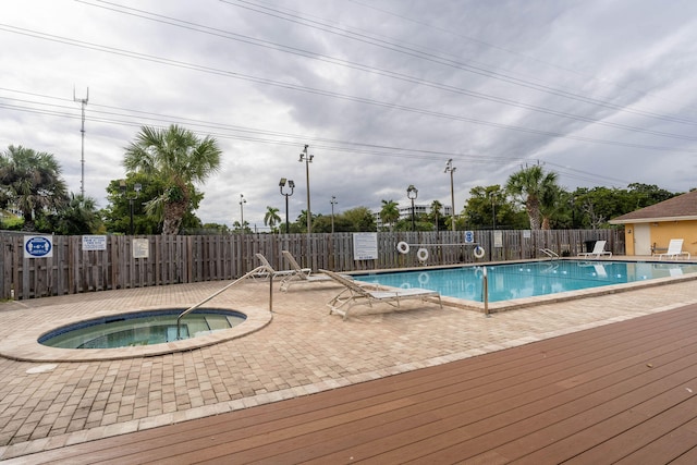 view of pool featuring a patio and a hot tub