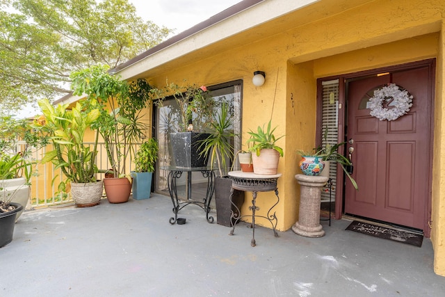 view of exterior entry with a patio area