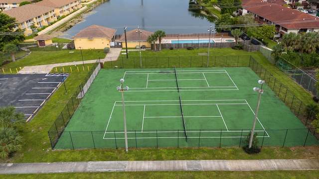 view of sport court with a lawn, a water view, and a community pool