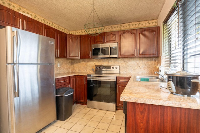 kitchen with a textured ceiling, appliances with stainless steel finishes, and sink