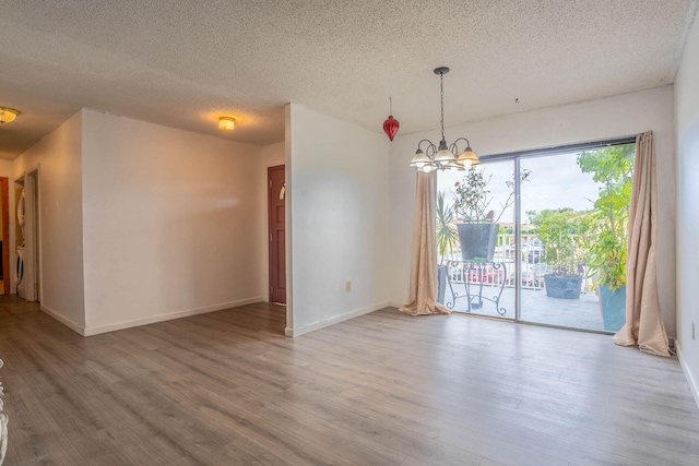 unfurnished room with a chandelier, a textured ceiling, and hardwood / wood-style flooring