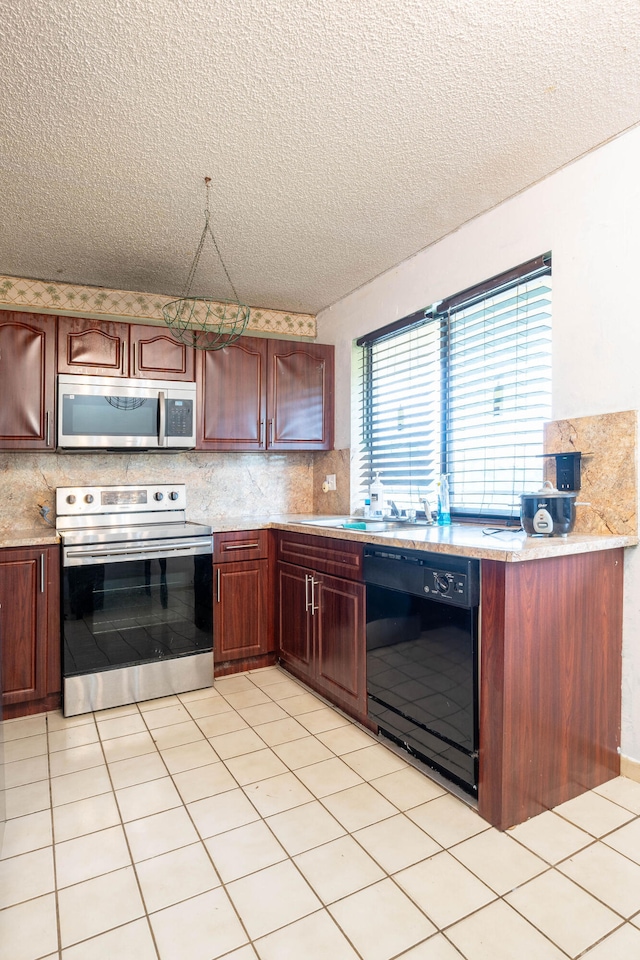 kitchen featuring stainless steel appliances, a textured ceiling, light tile patterned floors, and tasteful backsplash