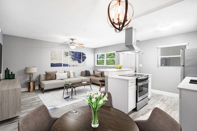 interior space with island exhaust hood, appliances with stainless steel finishes, light hardwood / wood-style floors, and white cabinetry