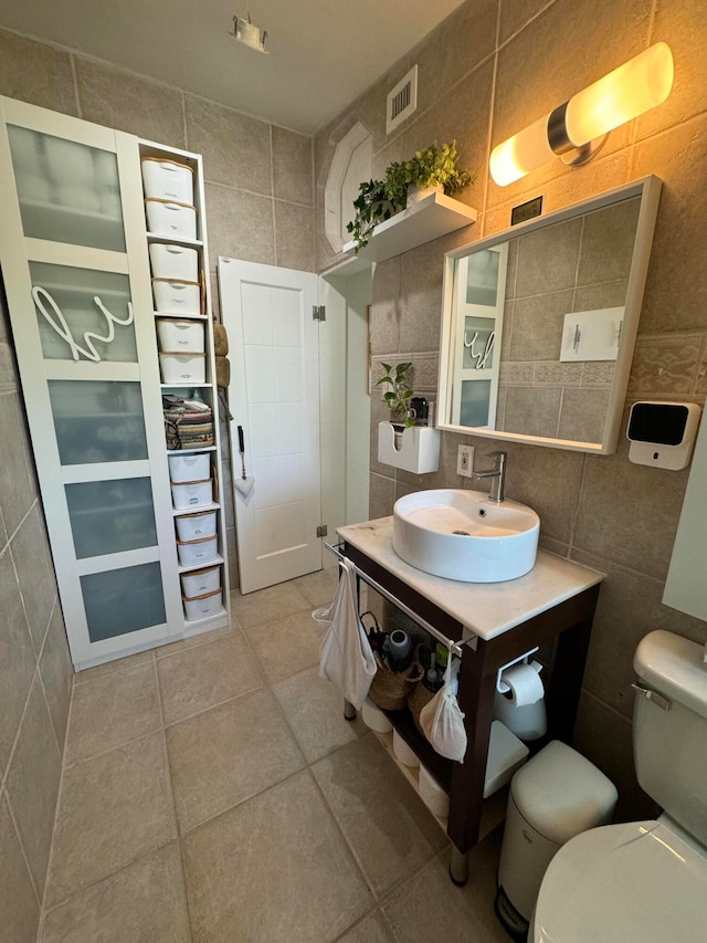 bathroom with tile walls, toilet, and vanity