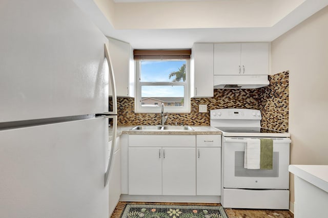 kitchen with backsplash, white appliances, white cabinetry, and sink