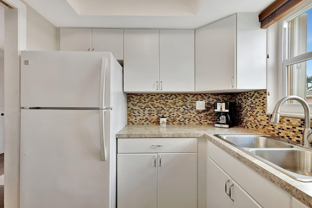 kitchen featuring white cabinets, white fridge, and sink