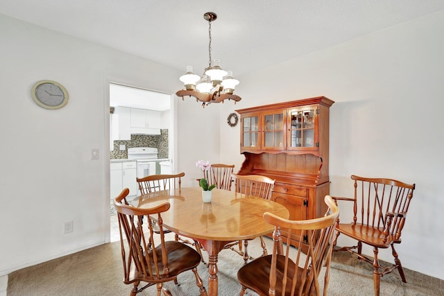 carpeted dining room with a chandelier