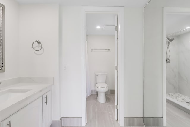 bathroom featuring walk in shower, toilet, and vanity