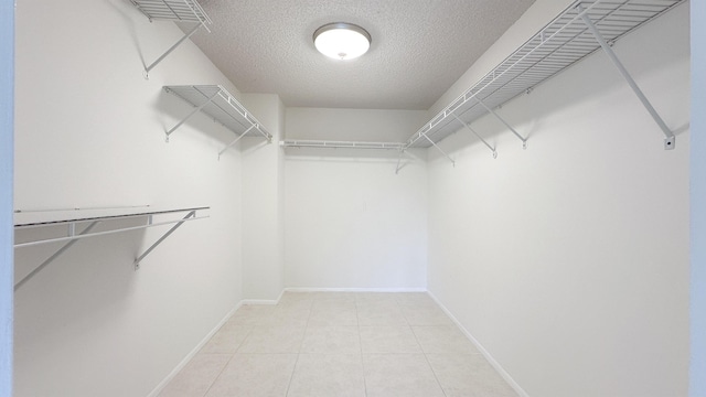 walk in closet with light tile patterned floors