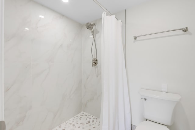 bathroom with a shower with shower curtain and toilet