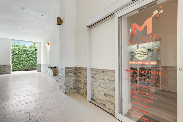 hallway with tile walls and floor to ceiling windows