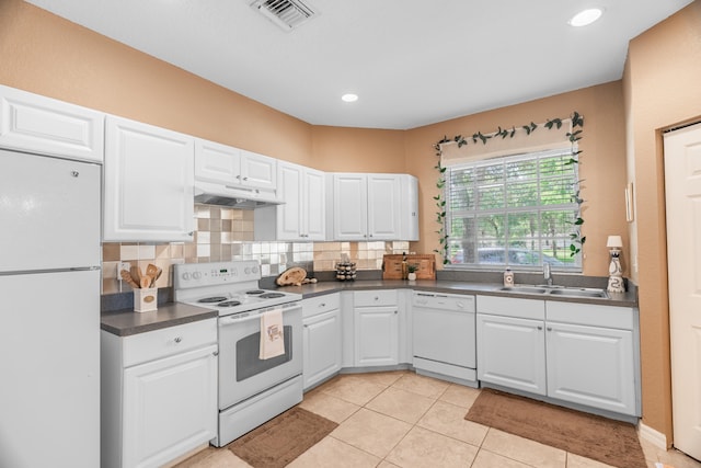 kitchen featuring white cabinets, light tile patterned floors, sink, white appliances, and backsplash