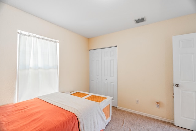 bedroom with light carpet and a closet