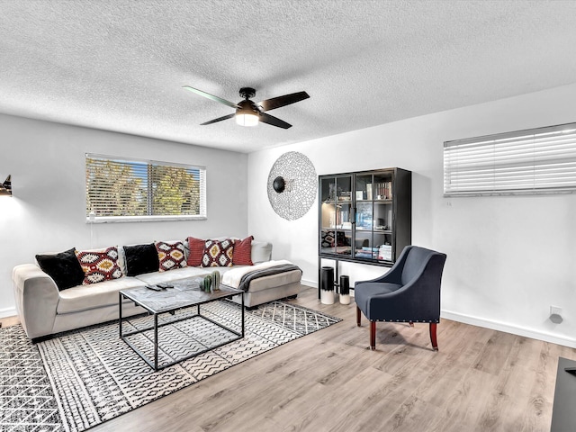 living room featuring hardwood / wood-style floors, a textured ceiling, and ceiling fan