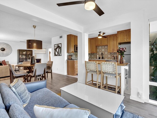 living room with dark hardwood / wood-style floors, a wealth of natural light, and ceiling fan