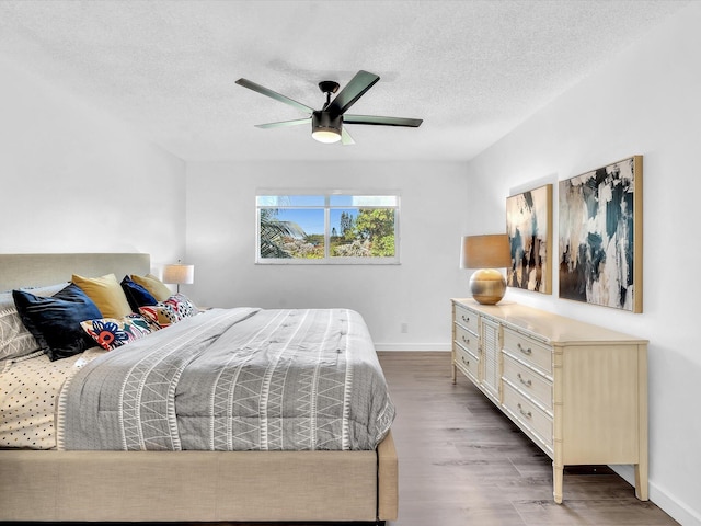 bedroom with a textured ceiling, hardwood / wood-style flooring, and ceiling fan