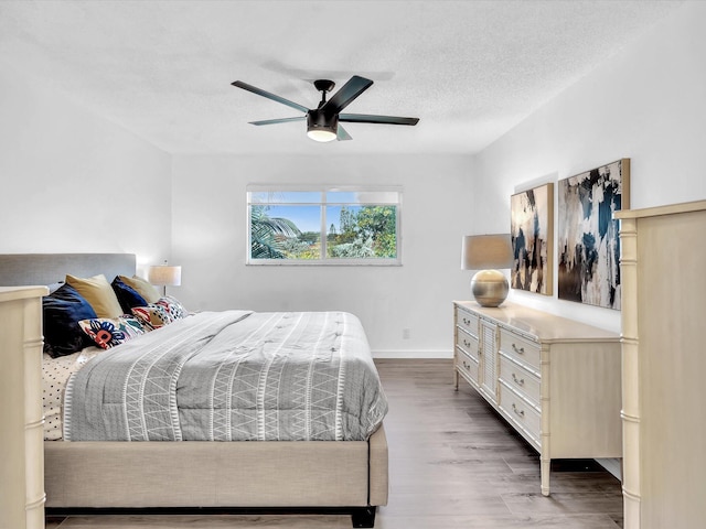 bedroom featuring ceiling fan, a textured ceiling, and hardwood / wood-style flooring