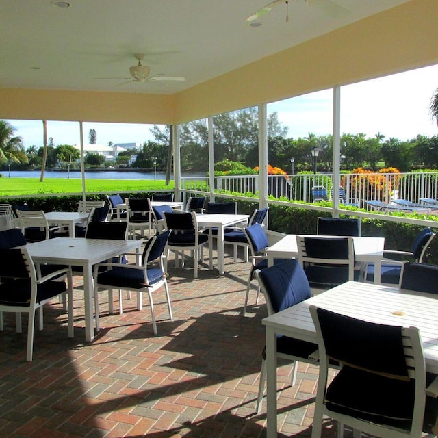 view of patio with ceiling fan and a water view