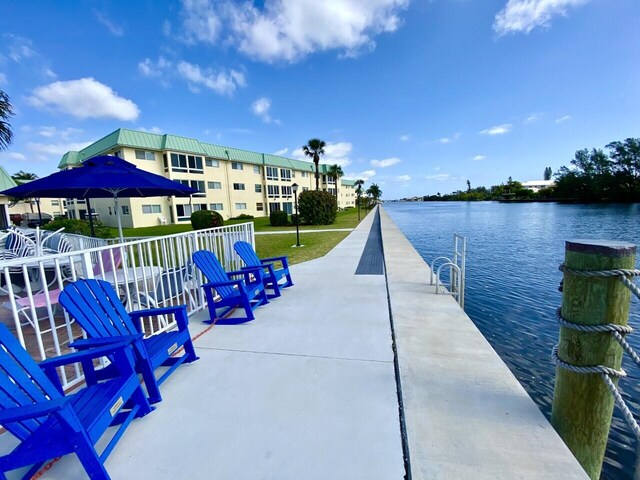 dock area featuring a water view and a lawn