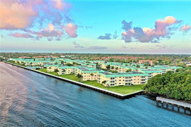 aerial view at dusk featuring a water view