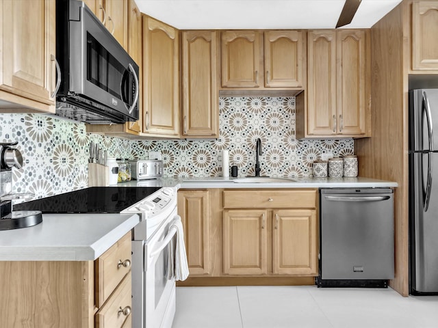 kitchen with light tile patterned flooring, sink, stainless steel appliances, and tasteful backsplash