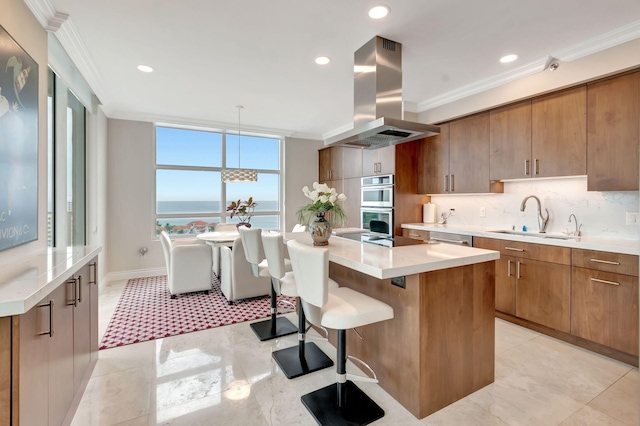 kitchen featuring a water view, island exhaust hood, sink, and a kitchen island