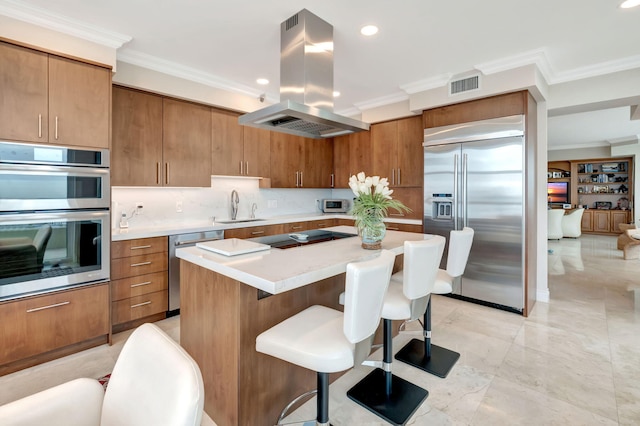 kitchen with island exhaust hood, stainless steel appliances, a center island, sink, and tasteful backsplash