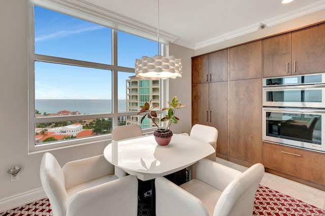 tiled dining space featuring ornamental molding and a water view