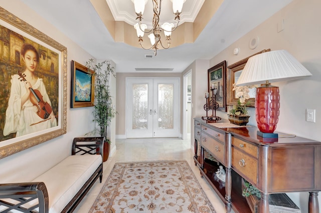 entrance foyer featuring french doors, a raised ceiling, an inviting chandelier, and crown molding